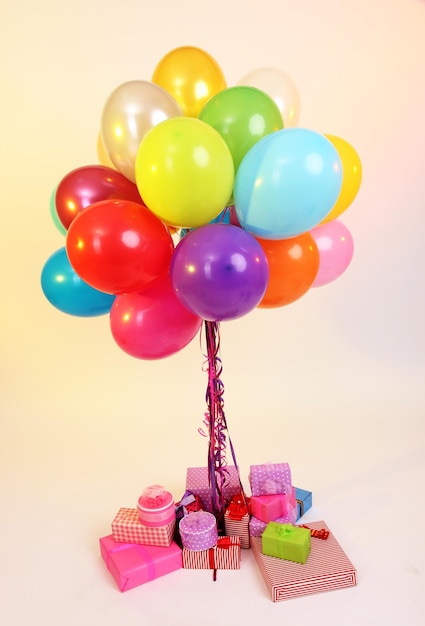 Viele helle Luftballons und viele Geschenke auf hellem Hintergrund