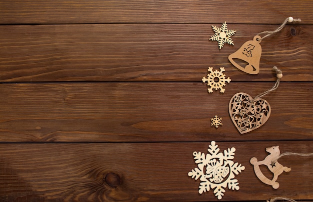 Viele hölzerne Spielzeuge für Weihnachtsbaum auf hölzernem Hintergrund Draufsicht.