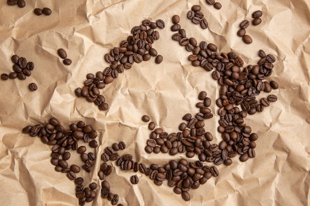 Viele Kaffeebohnen auf Kraftpapier verstreut