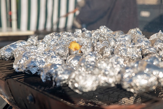 Viele Kartoffeln in Folie auf dem Grill