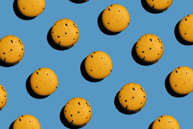 Viele köstliche gelbe Makronen auf blauem Hintergrund