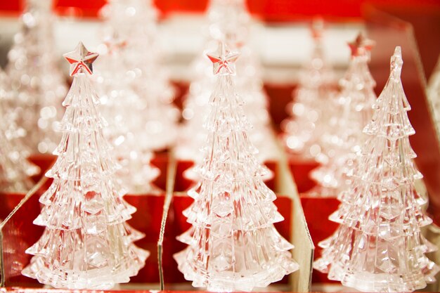 Viele kristallene kleine dekorative Tanne in roter Box im Shop. Weihnachtsmarkt. Nahaufnahme.