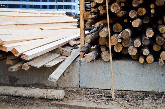 Viele lange, natürlich gehobelte Holzstämme und Bretter in einem Sägewerk Das Hintergrund-Textur-Konzept