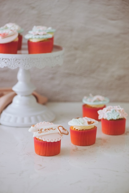 Viele leckere Cupcakes. Valentinsgruß süßer Liebescupcake auf dem Tisch auf hellem Hintergrund