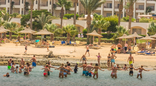 Viele Leute machen rhythmische Gymnastik im Wasser am Strand