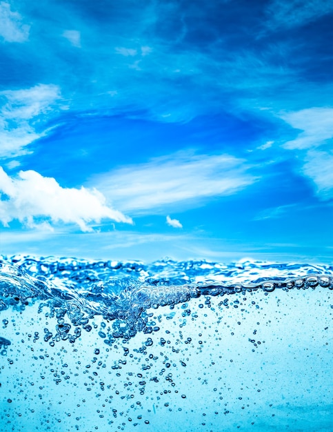 Viele Luftblasen im Wasser hautnah, abstrakte Wasserwelle mit Blasen auf einem Hintergrund des blauen Himmels