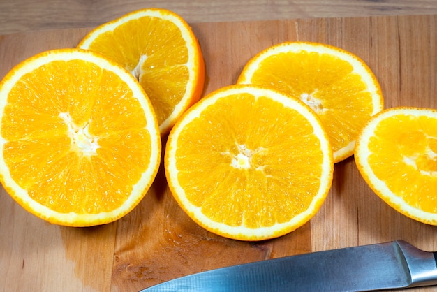 Viele Orangenscheiben liegen auf einem Küchenbrett aus Holz. Frische Zitrusfrüchte.