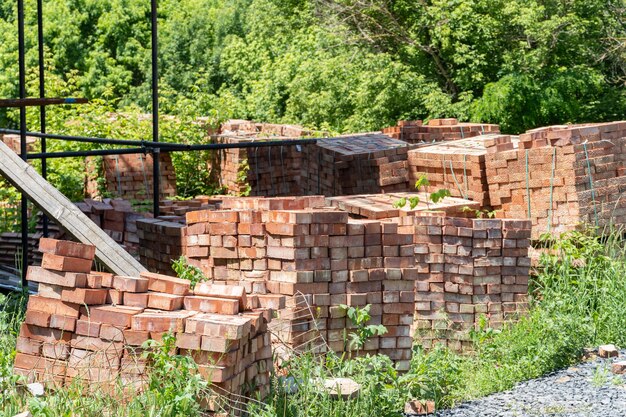 Viele Paletten mit roten Keramikziegeln auf einer Baustelle