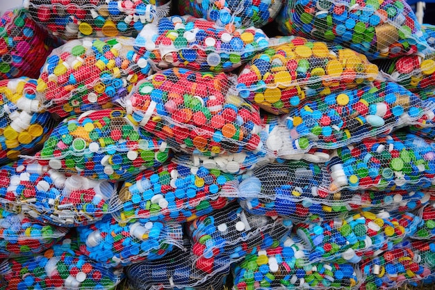 Viele Plastikflaschendeckel in riesigen Einwegtüten