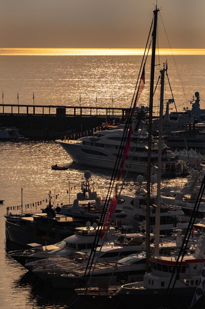 Viele riesige Yachten sind im Hafen von Monaco bei Sonnenaufgang glänzendes Brett des Motorboots die Chromplattierung ...