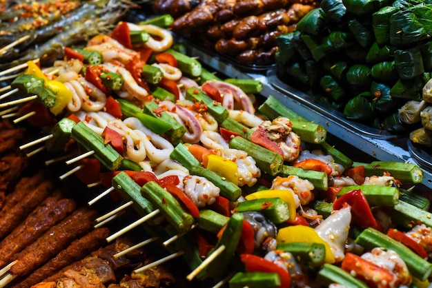 Viele rohe Tintenfische am Spieß und Meeresfrüchte auf dem vietnamesischen Nachtmarkt in Da Lat