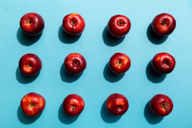 Viele rote Äpfel auf Draufsicht des farbigen Hintergrundes Herbstmuster mit frischem Apfel über Ansicht
