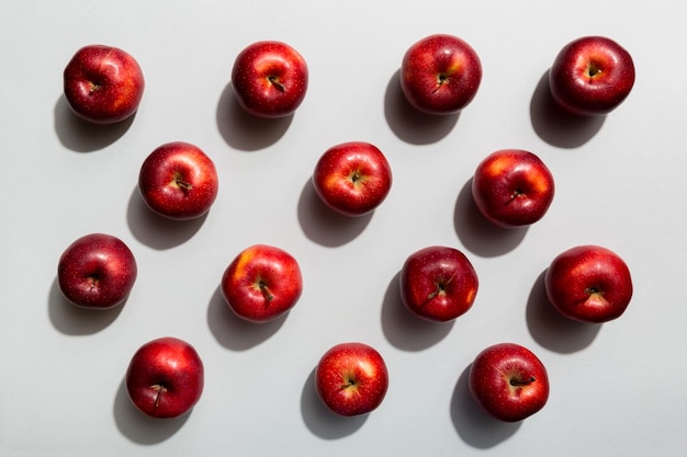 Viele rote Äpfel auf Draufsicht des farbigen Hintergrundes Herbstmuster mit frischem Apfel über Ansicht