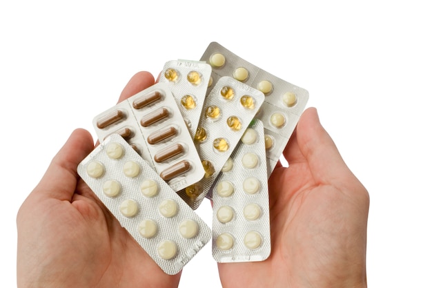 Viele Tabletten in Händen isoliert auf Weiß