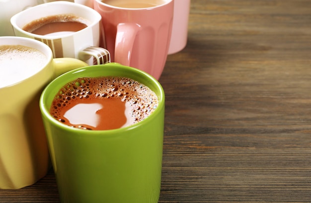 Viele Tassen Kaffee auf Holzhintergrund