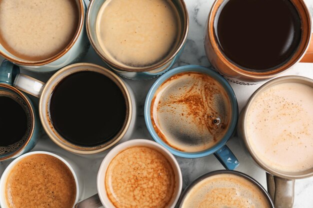 Foto viele tassen verschiedener aromatischer heißer kaffees auf der tischplatte