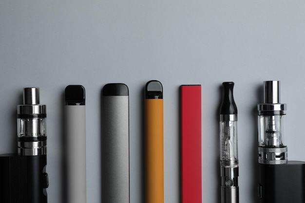 Viele verschiedene elektronische Zigaretten auf hellem Hintergrund liegen flach