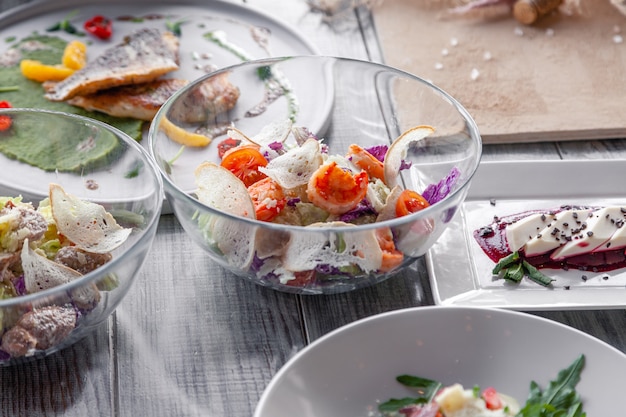 Viele verschiedene Gerichte, Fisch und Salate werden am Tisch im Restaurant serviert.