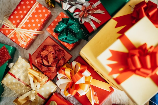 Viele verschiedene Geschenkboxen auf dem Boden in der Nähe des Weihnachtsbaums zu Hause.