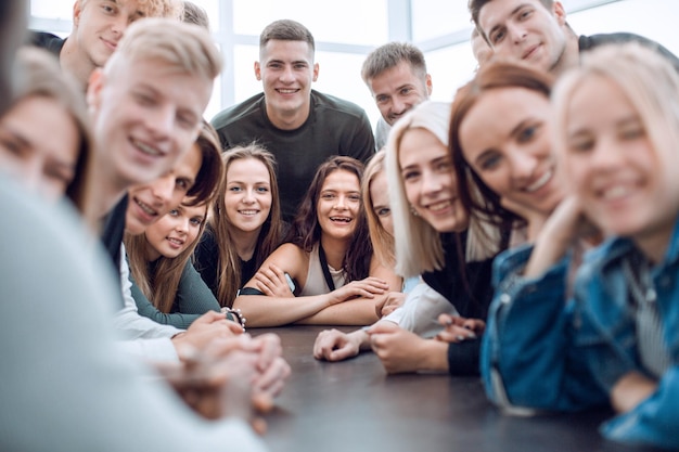 Foto viele verschiedene junge leute sitzen an einem tisch