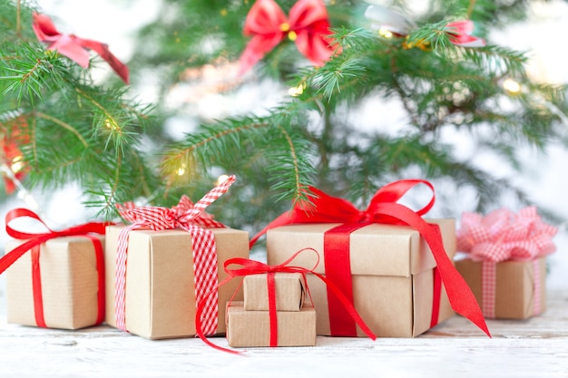 Viele Weihnachtsgeschenkboxen mit rotem Band unter dem Weihnachtsbaum