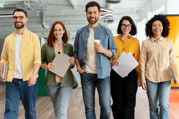 Vielfältige Gruppe erfolgreicher Büroangestellter, Vertriebsleiter, die in einem modernen Büro spazieren gehen