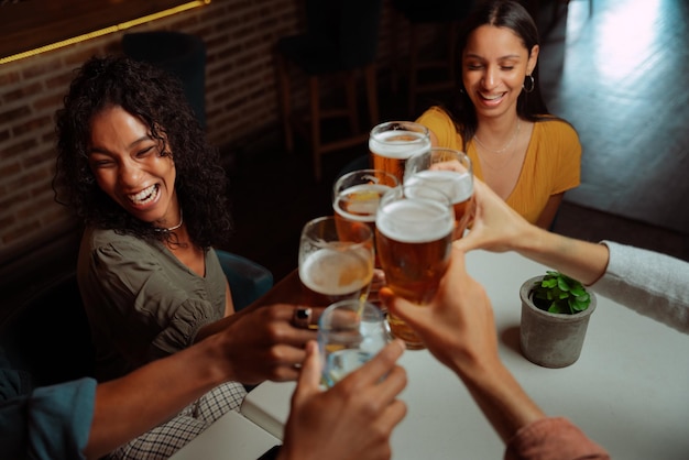Vielfältige Gruppe von Freunden, die Bier trinken gehen und anstoßen