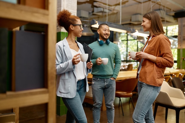 Vielfältiges Geschäftsteam lacht fröhlich im Coworking Office