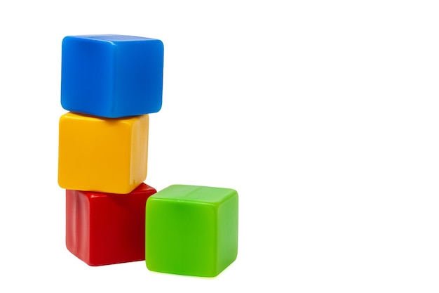 Vielfarbige Plastikwürfel für Kinderspiele Gelber Würfel steht auf einem roten und blauen Würfel