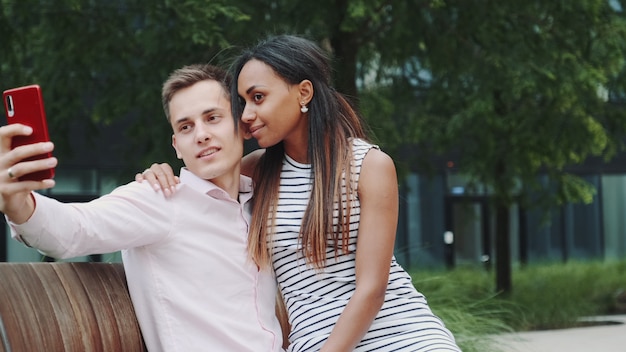 Vielpunkt Mädchen und Junge in der Liebe umarmen und Selfie nehmen.