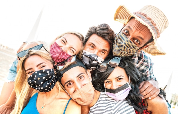 Vielpunkt Milenial Freunde nehmen Selfie lächelnd hinter Gesichtsmasken