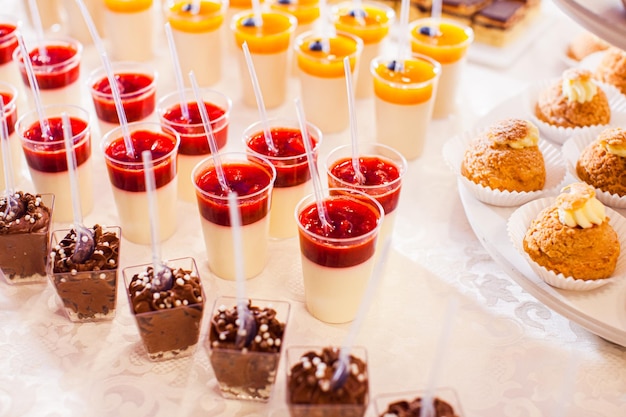 Vielzahl köstlicher Desserts mit Früchten auf einem süßen Buffet Leckeres Pannacotta-Mousse-Dessert und Choux-Brötchen für die Party