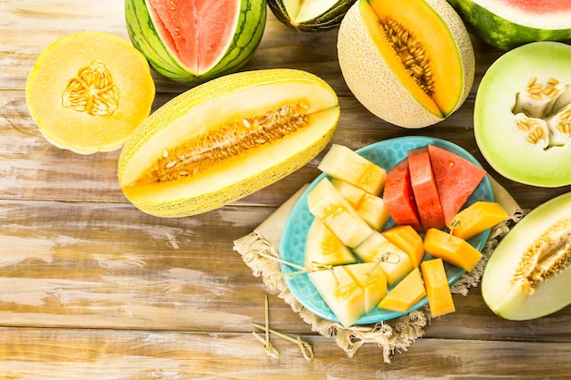 Vielzahl von Bio-Melonen auf Holztisch geschnitten.