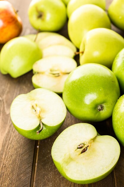 Vielzahl von Bio-Äpfeln auf Holztisch geschnitten.