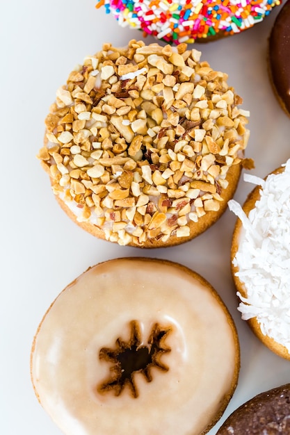 Vielzahl von frischen Donuts auf weißem Hintergrund.