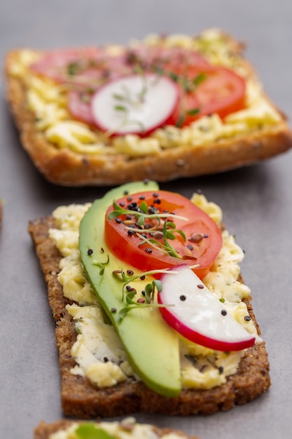 Vielzahl von Mini-Sandwiches mit Frischkäse, Gemüse und Salami.