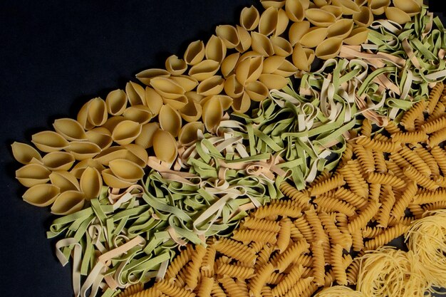 Vielzahl von Typen und Formen trockener italienischer Pasta Italienischer Makkaroni-Rohkosthintergrund oder Texturpasta-Spaghetti-Nudeln in Form einer Spirale