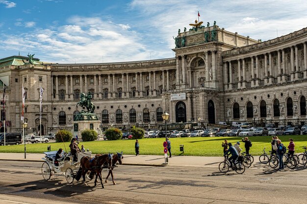 Foto viena 28 de setembro de 2022 palácio de hofburg e praça panorâmica pessoas caminhando e fiaker com cavalos em viena áustria