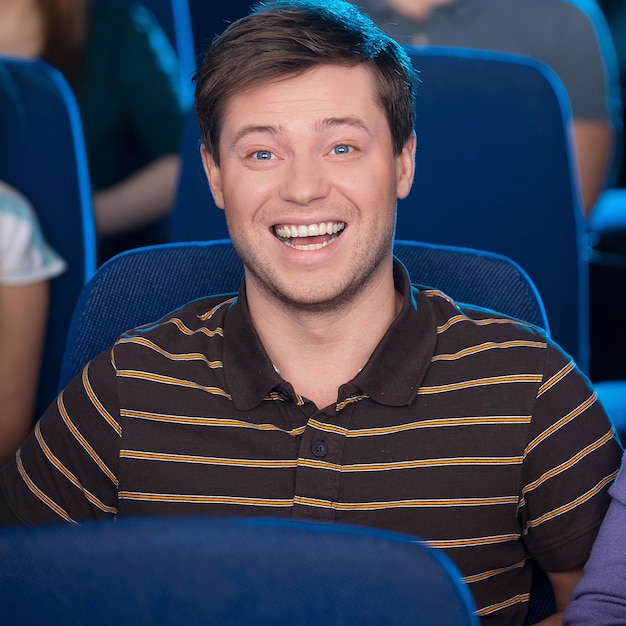 Viendo una película juntos. Feliz pareja joven comiendo palomitas de maíz y bebiendo refrescos mientras ve la película en el cine