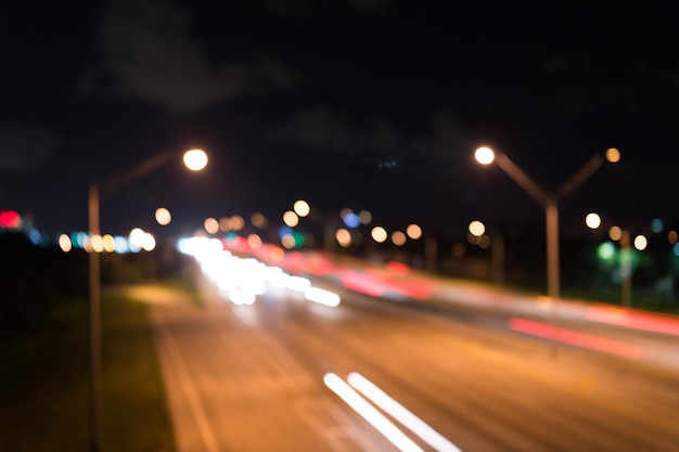 Foto viendo el transporte en movimiento en la calle. tráfico urbano. noche de luces de coche borrosa. noche urbana. luces de fondo desenfocado. luces de la ciudad de noche. iluminación e iluminación. lámparas borrosas blancas y rojas.