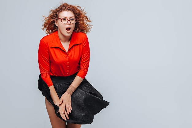 El viento levanta su falda chica pelirroja con blusa roja