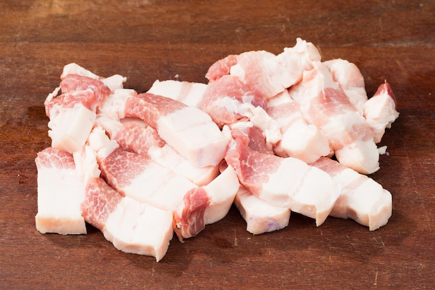 Vientre de cerdo cortado en cubitos frescos en una tabla de cortar