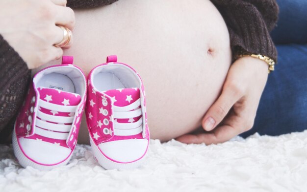 Vientre de una chica embarazada con botines