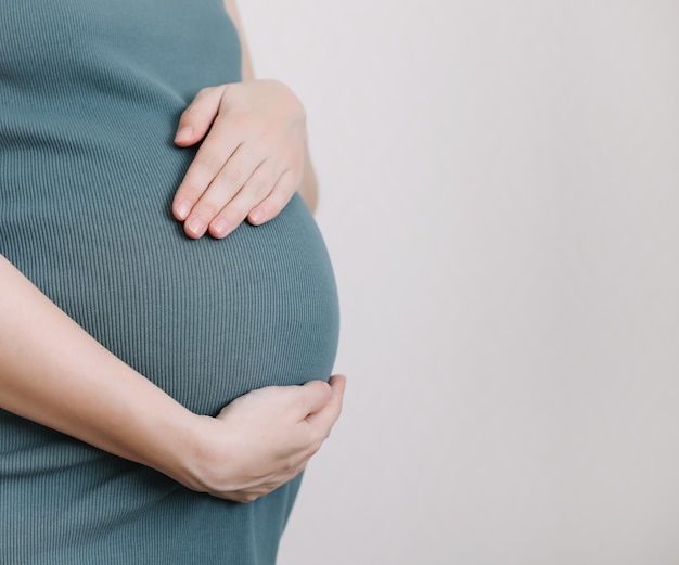 Foto vientre de mujer embarazada con botitas de bebé