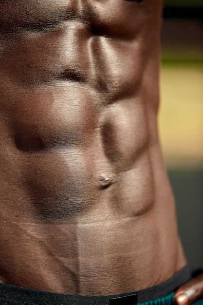 Vientre musculoso masculino, primer plano, alivio abdominal del hombre negro.