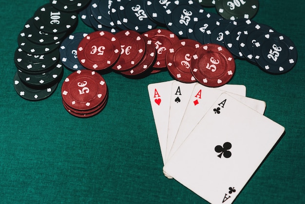 Vier Asse und Chips auf dem grünen Pokertisch