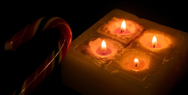Vier brennende Kerzen auf dunklem Hintergrund