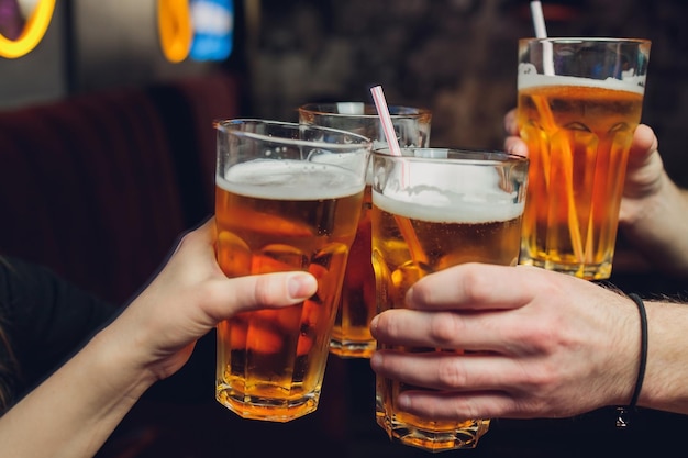 Vier Freunde mit einem frischen Bier in einer Biergartennahaufnahme auf Bierkrug