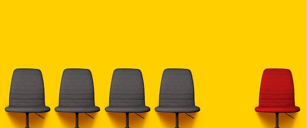 Vier graue Bürostühle und ein roter Stuhl auf einem gelben
