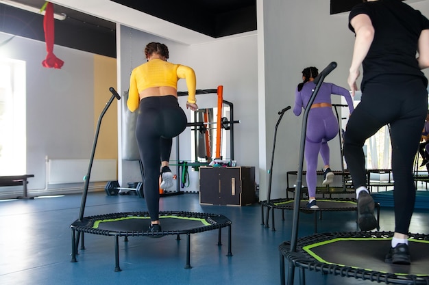 Vier junge Frauen auf dem Trampolin junge Fitness-Mädchen trainieren im Fitnessstudio